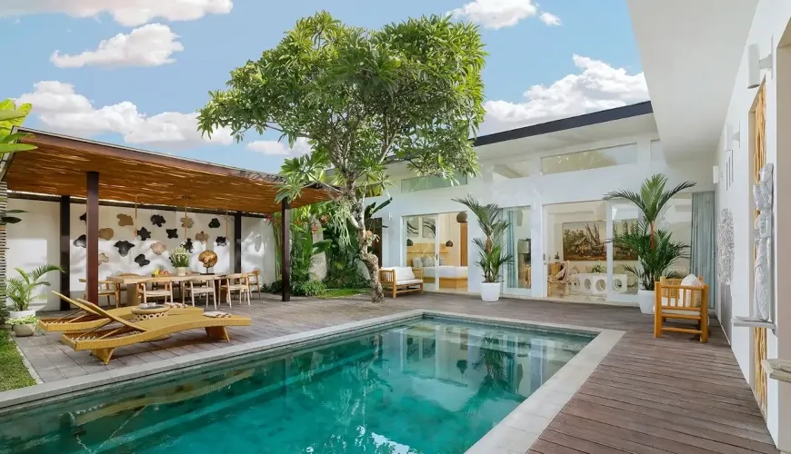Aerial view of a contemporary villa with a swimming pool, wooden deck, and outdoor furniture at The Suar Sanur