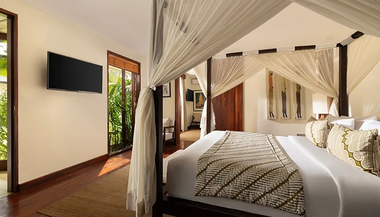 Bedroom with elegant four poster bed and beautiful garden view at The Suar Seminyak