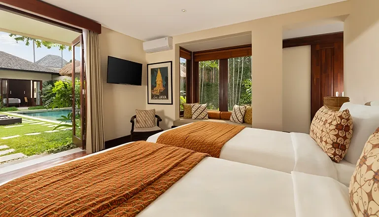Comfortable bedroom with twin beds and refreshing pool garden view at The Suar Seminyak