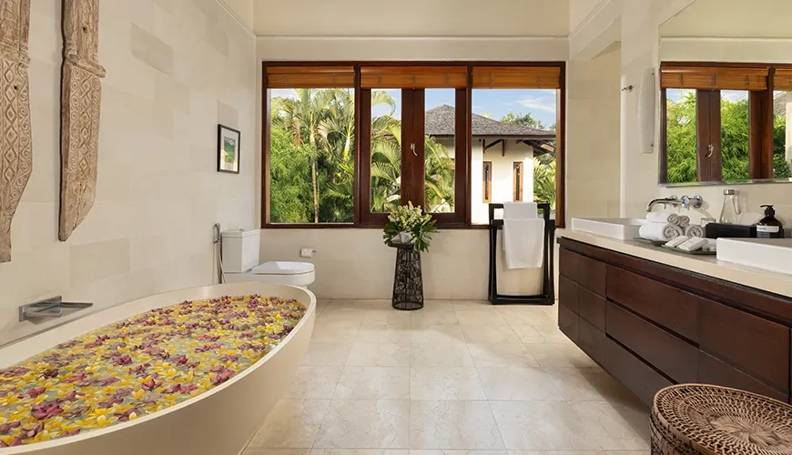 Luxurious bathroom with flower petal filled bathtub and double vanity at The Suar Seminyak