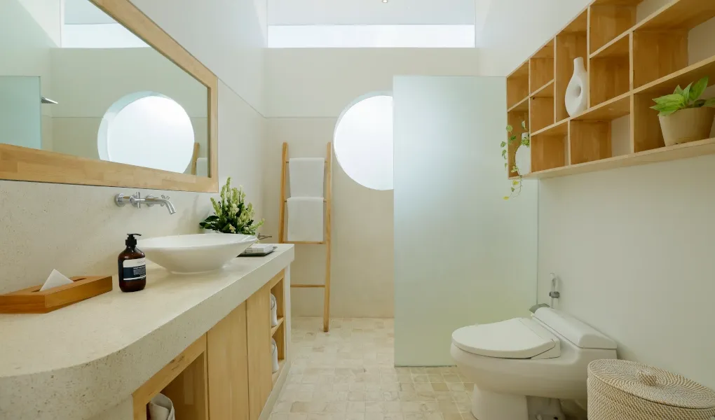 Bright minimalist bathroom with wooden accents and modern fixtures at The Suar Sanur
