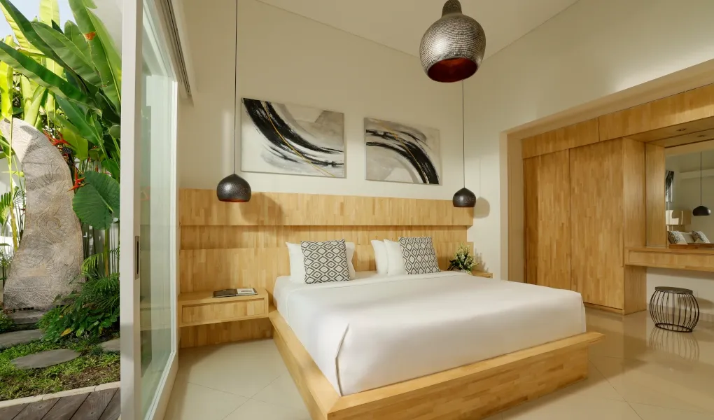 Luxurious bedroom with a king-size bed and direct access to a private pool at The Suar Sanur