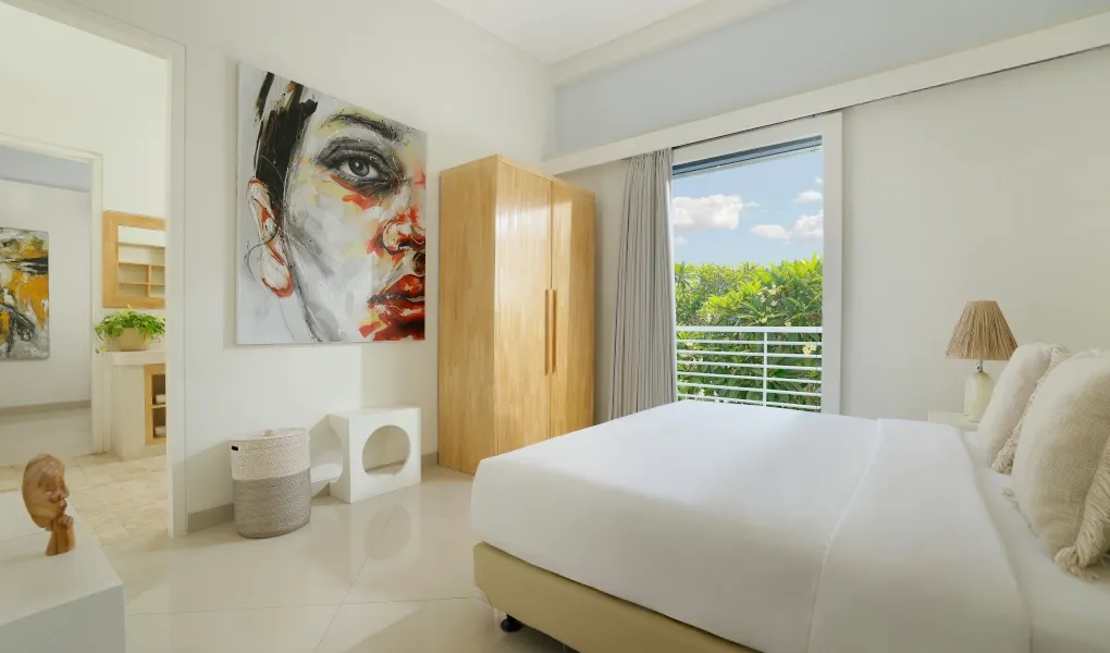 Modern, bright bedroom with unique artwork and wooden wardrobe The Suar Sanur