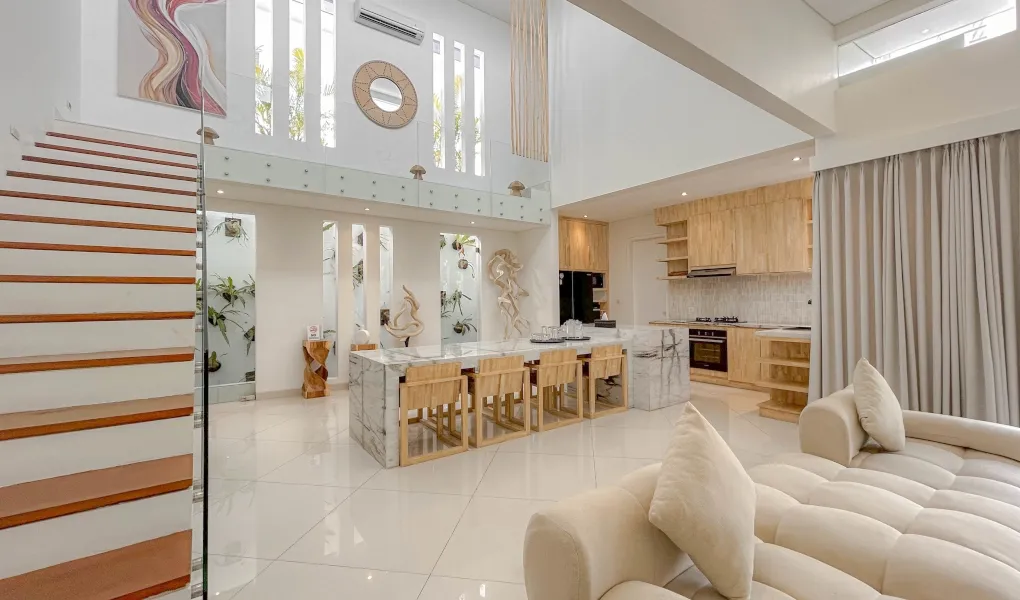 Spacious living area with a sectional sofa, coffee table, and wooden walls at The Suar Sanur