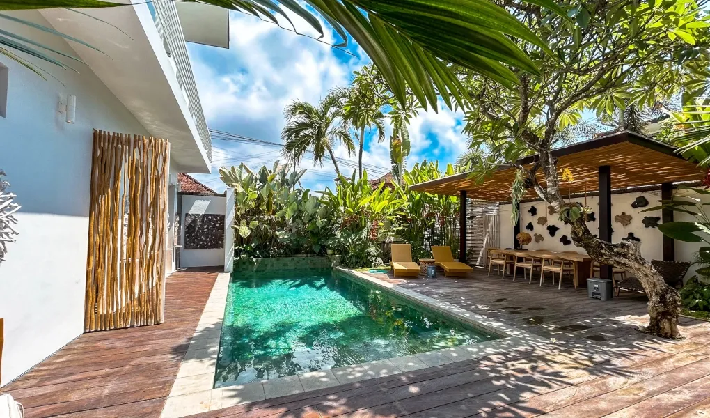 Sun loungers by a pool with steps leading into the water at The Suar Sanur