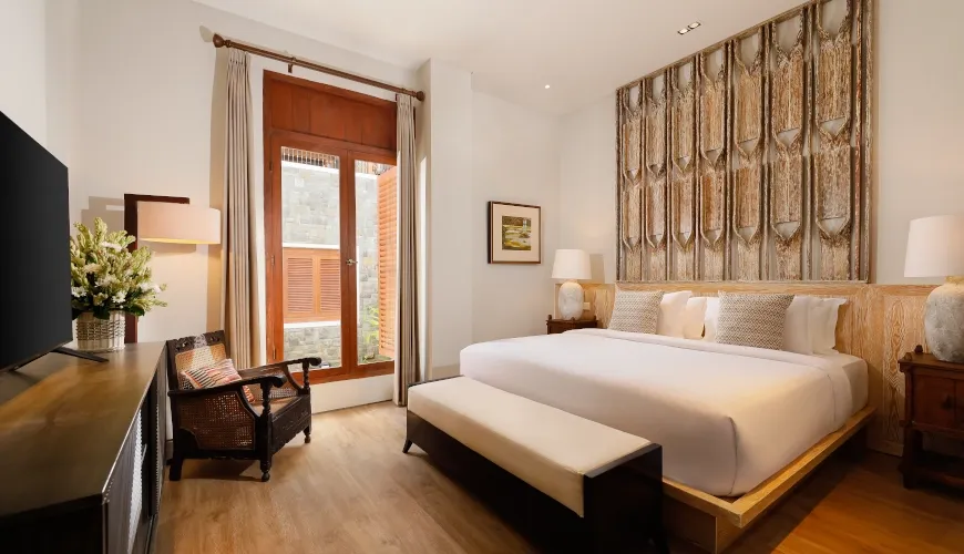 Cozy bedroom with a king-sized bed and a TV at The Tulou Bali Villa