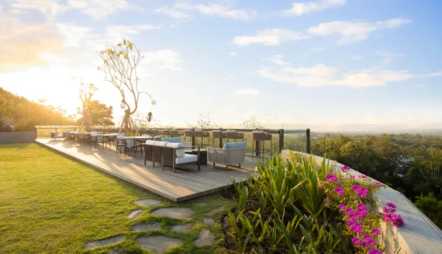 Outdoor seating area with a bar and scenic sunset views at Sky Lounge at The Tulou Bali Villa