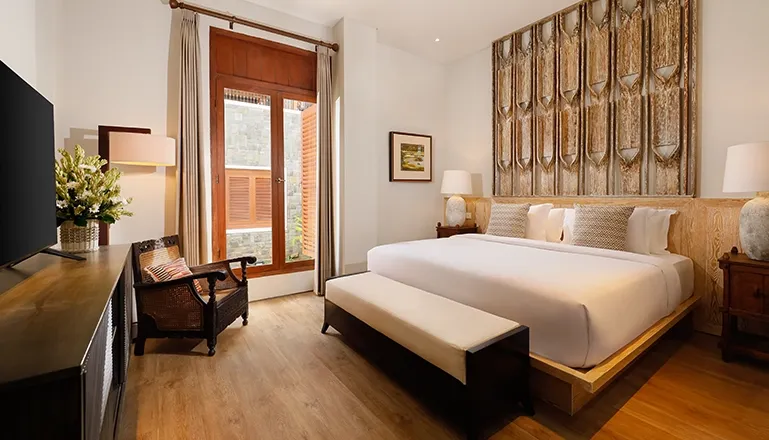 Luxury Bali villa bedroom with rustic wood details at The Tulou