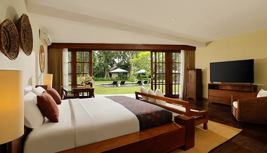 Spacious master suite featuring warm lighting and wood details at Tirtadari Villa