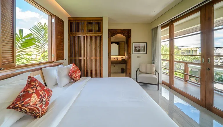 Cozy king bedroom with wooden frame and wardrobe at Uma Berawa VIlla