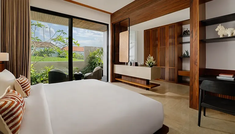 Spacious and elegant villa bedroom with a comfortable bed, a small desk, and a bright outdoor patio at Uma Santai Canggu