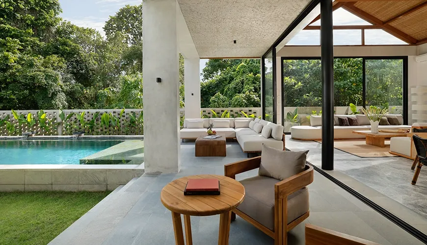 Luxurious outdoor terrace featuring a stylish lounge area with comfortable sofas and a swimming pool surrounded by lush greenery at Uma Santai Canggu
