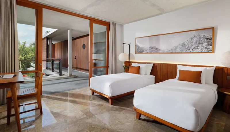 Modern villa twin bedroom with two comfortable single beds featuring sliding doors to the outdoor patio at Uma Santai Pererenan