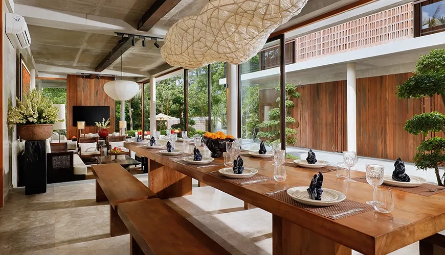 Spacious contemporary villa dining room with sliding glass doors overlooking a serene outdoor garden at Uma Santai Pererenan