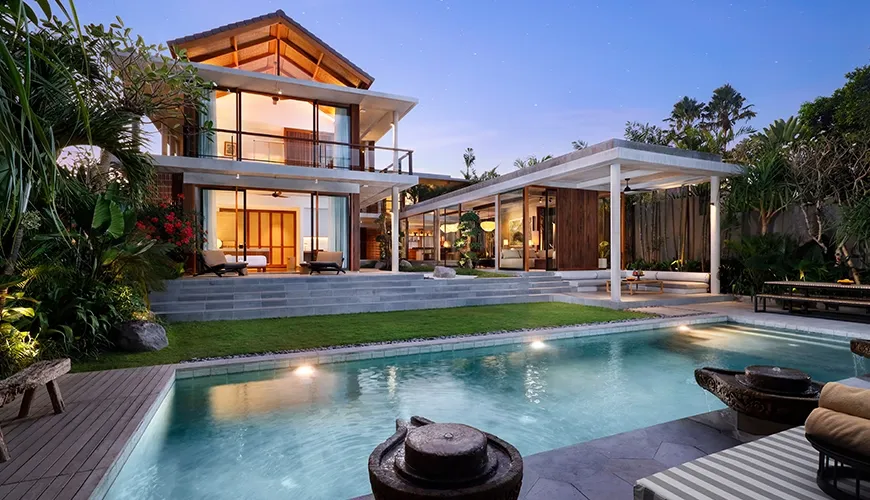 Stunning luxury villa exterior featuring a large private swimming pool surrounded by lush tropical landscaping at Uma Santai Pererenan