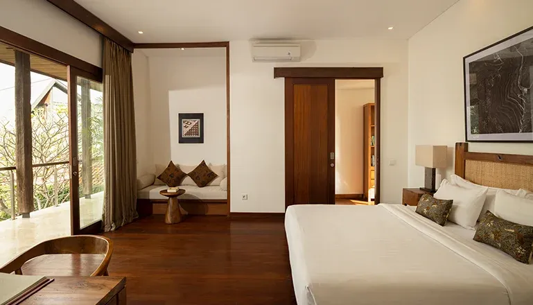Bright Bali bedroom with balcony and seating nook at Villa Ambara