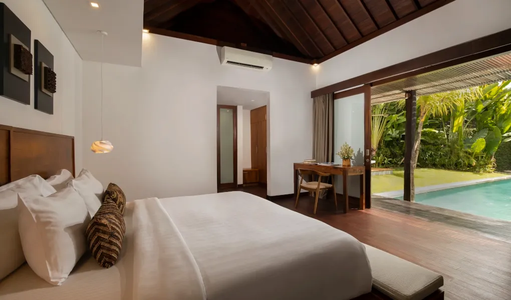 Master bedroom with direct pool access and tropical greenery at Villa Ambara