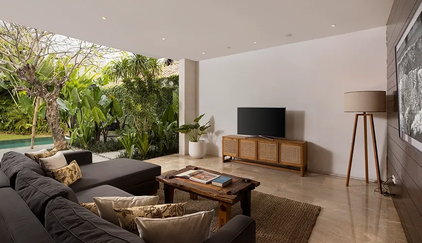 Modern living room with sectional sofa and open pool view at Villa Ambara