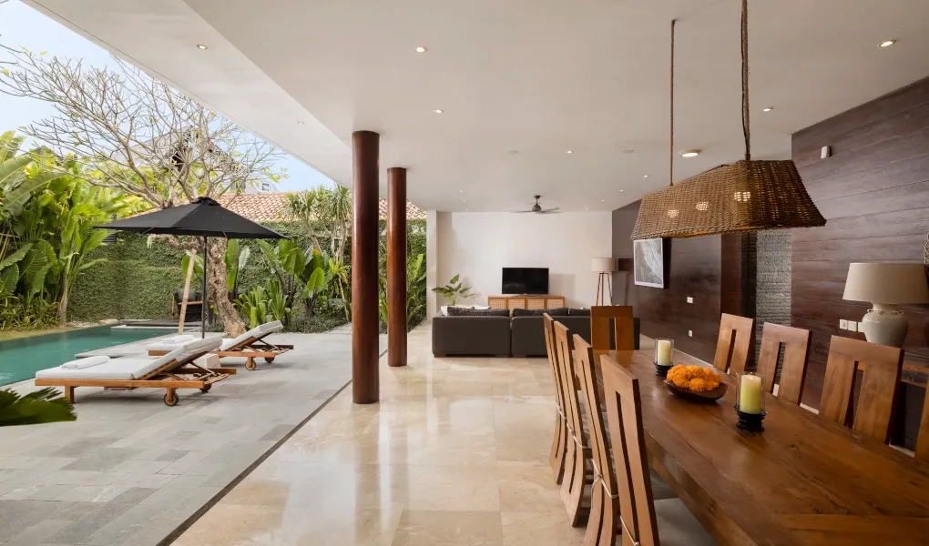 Spacious dining and living area adjacent to a swimming pool at Villa Ambara