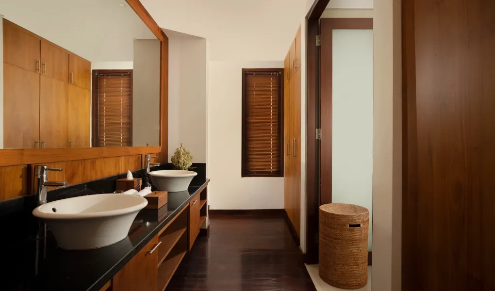 Spacious modern bathroom with a dual sink vanity and dark wood accents at Villa Ambara