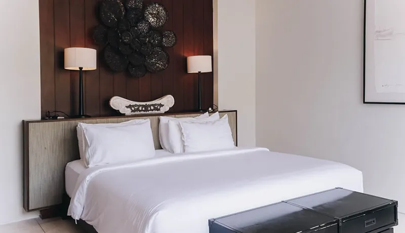 Elegant bedroom features a comfortable bed and distinctive dark accent wall at Villa Ambergris
