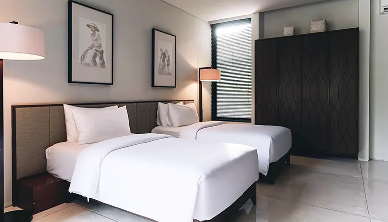 Modern bedroom features two single beds and stylish patterned wardrobe at Villa Ambergris