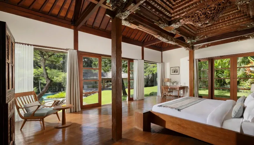 Bedroom with ornate wooden ceilings, a king-sized bed, and garden views at Villa Amita