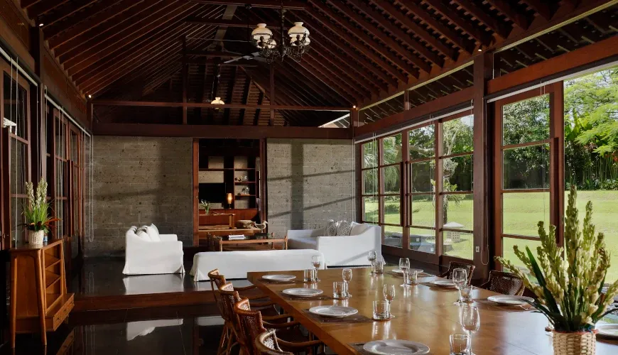 Spacious dining area with a long wooden table and open-plan living space at Villa Amita