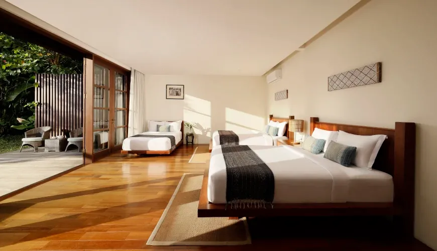 Spacious family bedroom with three beds and a private terrace at Villa Amita