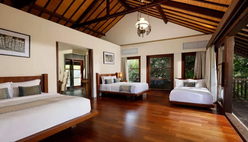 Spacious family room with three beds and high ceilings at Villa Amita