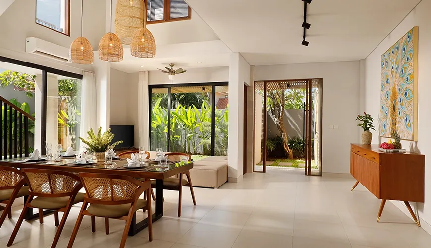 Bright living dining area with wooden table peacock painting at Villa Ananya