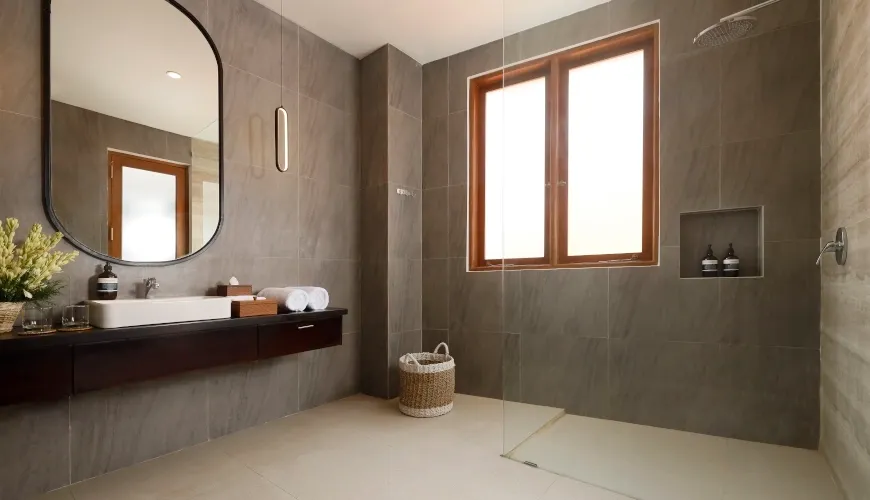 Contemporary grey tiled bathroom with sleek vanity and walk-in shower at Villa Ananya