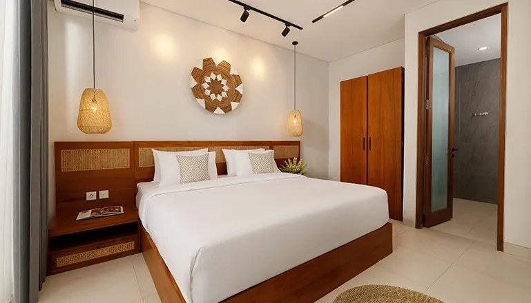 Cozy bedroom with wooden bed frame rattan headboard and modern lights at Villa Ananya