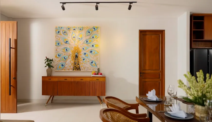Minimalist dining area with peacock artwork and modern Bali furniture at Villa Ananya