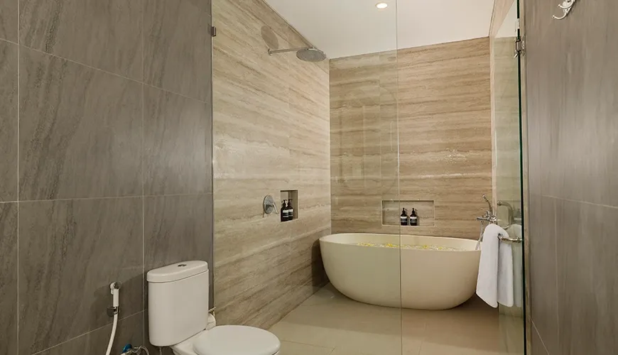 Modern bathroom with white oval bathtub and glass shower at Villa Ananya