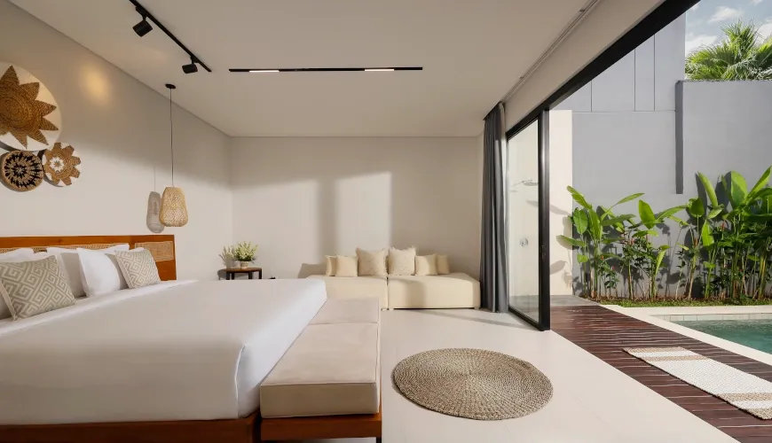 Modern minimalist master bedroom with direct access to a private pool at Villa Ananya