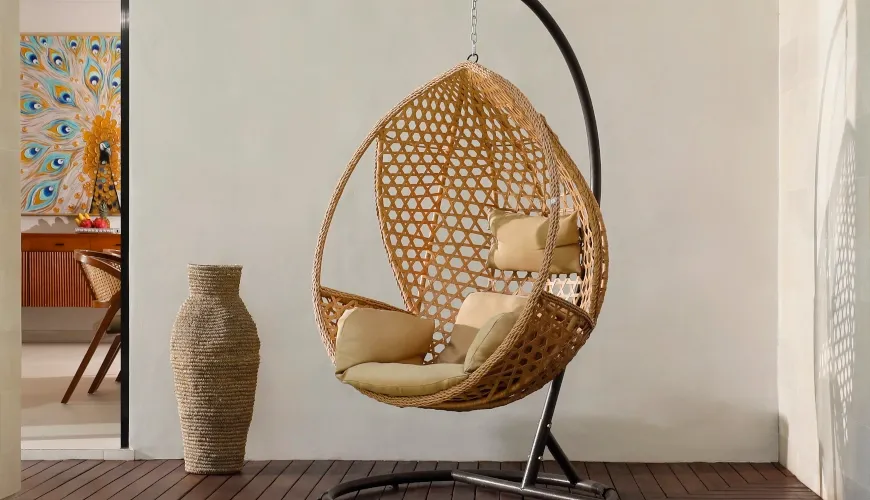 Rattan hanging swing chair on a wooden deck at Villa Ananya