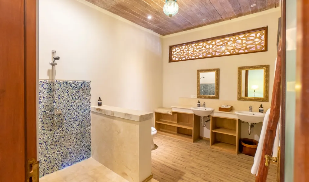 Bathroom with dual sinks and a blue mosaic tiled shower at Villa Angsa