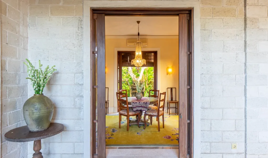 Luxury dining room with chandelier and large open doors at Villa Angsa