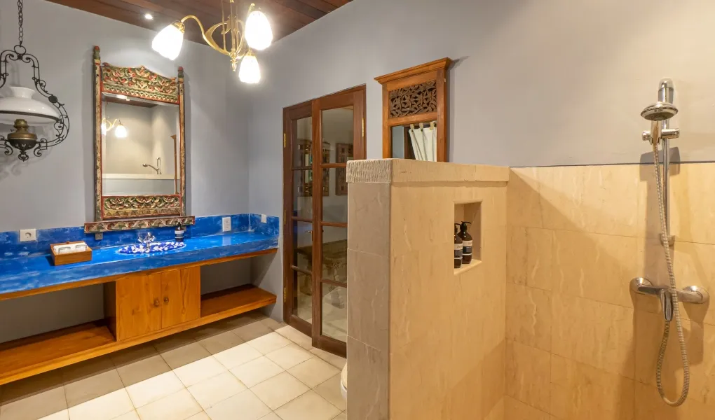 Modern bathroom with a blue marble vanity and ornate mirror at Villa Angsa