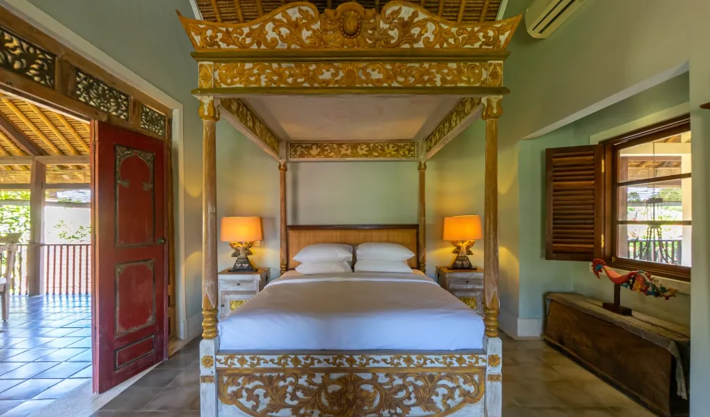 Ornate gold four-poster bed in a tranquil bedroom at Villa Angsa