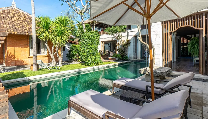 Outdoor swimming pool area with sun loungers and traditional villa architecture at Villa Angsa
