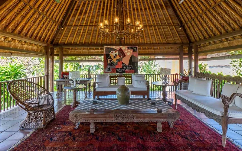 Spacious traditional living room with high thatched roof, large chandelier, and comfortable seating at Villa Angsa.