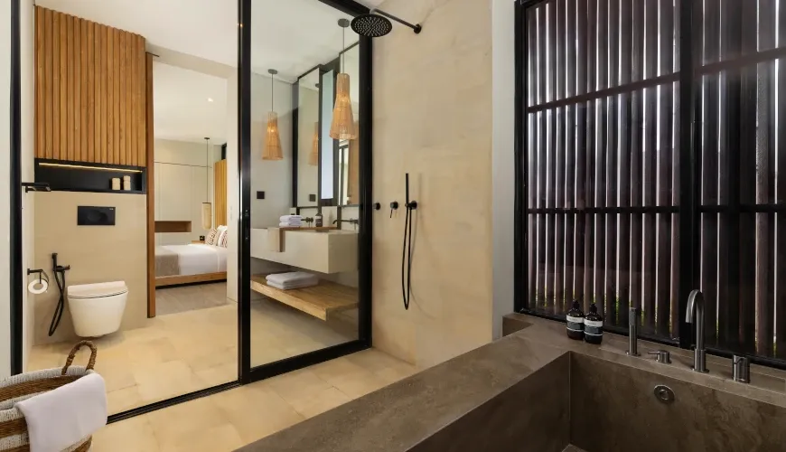 Luxury bathroom with a soaking tub and view into the bedroom at Villa Arita