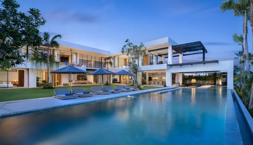 Modern villa with a large pool and loungers at dusk at Villa Arita