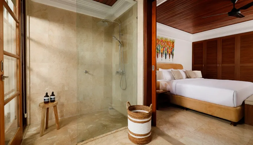 Spacious marble bathroom with a glass shower and direct bedroom access
