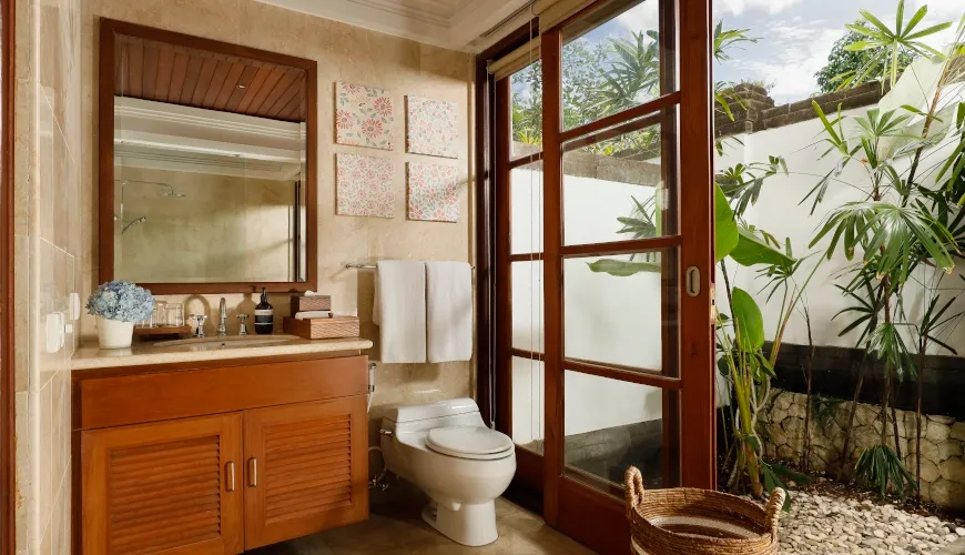 Traditional Balinese bathroom with marble counters and outdoor shower access at Villa Avaya