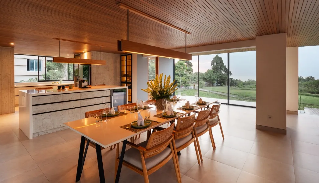 Elegant dining area with a modern kitchen and natural light at Villa Avocagolf