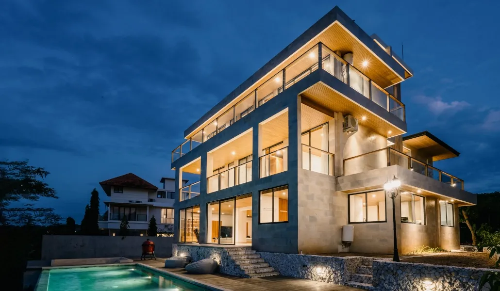Modern villa exterior with illuminated pool at night at Villa Avocagolf