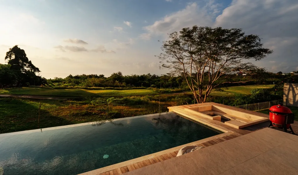 Serene outdoor pool with a sunken lounge area and sunset view at Villa Avocagolf